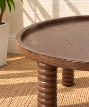 Load image into Gallery viewer, Lainey round dark walnut coffee table with raised rim, visible wood grain and four chunky ring-turned wood legs.
