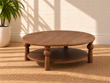 Load image into Gallery viewer, Leon two-tier coffee table in natural brown mango wood with a wide oval tabletop, lower shelf, and sculptural turned supports.
