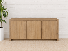 Load image into Gallery viewer, Levi three-door media cabinet in natural acacia wood with clean handle-free doors, visible wood grain and a low framed base.
