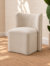 Load image into Gallery viewer, Lizbeth sand chenille accent chair with curved winged backrest, cushioned seat and fully upholstered rounded base.
