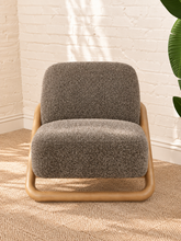 Load image into Gallery viewer, Lucia lounge chair with textured mocha upholstery, rounded seat and back, and sculptural curved natural wood sled frame
