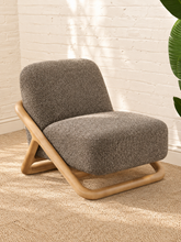 Load image into Gallery viewer, Lucia lounge chair with textured mocha upholstery, rounded seat and back, and sculptural curved natural wood sled frame
