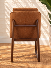 Load image into Gallery viewer, Lucy cushioned dining chair in cinnamon basketweave upholstery with a rounded sculptural back and rubber wood details.
