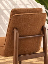 Load image into Gallery viewer, Lucy cushioned dining chair in cinnamon basketweave upholstery with a rounded sculptural back and rubber wood details.
