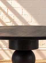 Load image into Gallery viewer, Mabel charcoal reclaimed pine round dining table with stacked cylindrical and spherical sculptural pedestal base.
