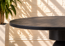 Load image into Gallery viewer, Mabel charcoal reclaimed pine round dining table with stacked cylindrical and spherical sculptural pedestal base.
