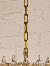 Load image into Gallery viewer, Maine chandelier with cascading tiers of elongated textured clear glass pieces suspended from an iron frame and chain.
