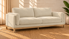 Load image into Gallery viewer, Image 2 of 4: Maraiah upholstered sofa in Oat Milk Mélange Chenille with low-profile silhouette and weathered wood base
