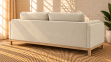 Load image into Gallery viewer, Image 3 of 4: Maraiah upholstered sofa in Oat Milk Mélange Chenille with low-profile silhouette and weathered wood base
