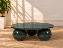 Load image into Gallery viewer, Martha round Forest Night marble coffee table with three spherical ball-shaped bases and natural dark green stone veining.
