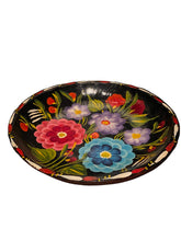 Load image into Gallery viewer, A Mexican Folk Art round black decorative bowl with hand-painted colorful flowers and green leaves, set against a dark background.
