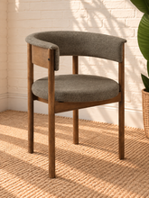 Load image into Gallery viewer, Mila mocha upholstered dining chair with curved open back, round cushioned seat, warm wood frame, and cylindrical legs
