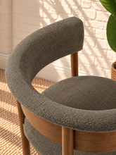 Load image into Gallery viewer, Mila mocha upholstered dining chair with curved open back, round cushioned seat, warm wood frame, and cylindrical legs
