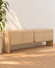 Load image into Gallery viewer, Miles natural light wood credenza in mindi and bayor wood with four rounded cabinet fronts, subtle wood grain, and waterfall-style sides.

