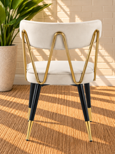 Load image into Gallery viewer, Morse dining chair in Pearl Cream velvet with matte black metal legs and gold frame and leg tip details
