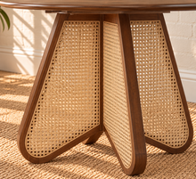 Load image into Gallery viewer, Nabi round dining table in Natural Brown with walnut finish and sculptural natural cane-inset pedestal base.
