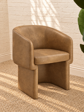 Load image into Gallery viewer, Nadia tan pebbled vegan leather dining armchair with rounded barrel back, sloped arms, cushioned seat, and fully upholstered base
