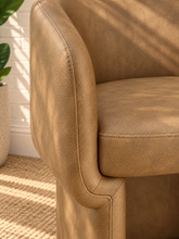 Load image into Gallery viewer, Nadia tan pebbled vegan leather dining armchair with rounded barrel back, sloped arms, cushioned seat, and fully upholstered base
