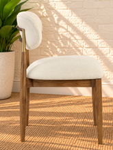 Load image into Gallery viewer, Nancy dining chair upholstered in Oat Milk performance fabric with Brown Walnut Ash Wood frame and brushed brass accents
