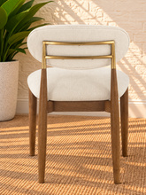 Load image into Gallery viewer, Nancy dining chair upholstered in Oat Milk performance fabric with Brown Walnut Ash Wood frame and brushed brass accents
