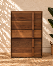 Load image into Gallery viewer, Nixon five-drawer dresser in warm walnut veneer with natural wood grain and integrated vertical wood pulls.
