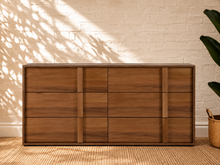 Load image into Gallery viewer, Nixon six-drawer dresser in warm walnut veneer with integrated vertical wood pulls and natural wood grain drawer fronts.
