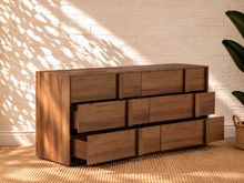 Load image into Gallery viewer, Nixon six-drawer dresser in warm walnut veneer with integrated vertical wood pulls and natural wood grain drawer fronts.
