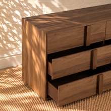 Load image into Gallery viewer, Nixon six-drawer dresser in warm walnut veneer with integrated vertical wood pulls and natural wood grain drawer fronts.
