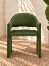 Load image into Gallery viewer, Nora olive green velvet dining armchair with curved barrel back, open-back design, angular arms, and upholstered panel base
