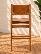 Load image into Gallery viewer, Nova counter stool in natural brown genuine leather with a tall teak wood frame, leather seat and backrest, footrest, and buckle strap detail.
