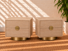 Load image into Gallery viewer, Pair of Jimena two-drawer nightstands in blonde oak with brushed brass metal bases and handles.
