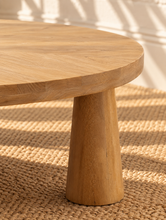 Load image into Gallery viewer, Rae coffee table in natural mango wood with a wide oval tabletop, rounded edges, and sculptural pedestal-style base.
