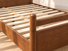 Load image into Gallery viewer, Rocco King platform bed with Walnut rubberwood frame, Greige heathered fabric headboard pillow, and faux leather straps.
