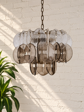 Load image into Gallery viewer, Rocio chandelier with layered clear and smoky sculptural glass pieces suspended from an iron frame and chain.
