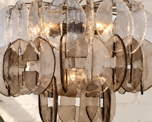 Load image into Gallery viewer, Rocio chandelier with layered clear and smoky sculptural glass pieces suspended from an iron frame and chain.
