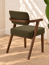 Load image into Gallery viewer, Royce dining armchair with deep olive textured upholstery, curved cushioned back, and walnut-finished solid rubberwood frame.
