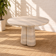 Load image into Gallery viewer, Selah round dining table with warm faux travertine finish, softly patterned top, and sculptural rounded pedestal base.
