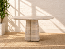 Load image into Gallery viewer, Selah round dining table with warm faux travertine finish, softly patterned top, and sculptural rounded pedestal base.
