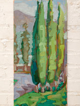 Load image into Gallery viewer, An impressionistic vertical canvas painting of tall green cypress trees, displayed on a white painted brick wall.
