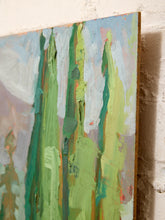 Load image into Gallery viewer, An abstract canvas painting with thick vertical brushstrokes in green, yellow, blue, white, and soft pink tones, shown leaning against a textured off-white wall.
