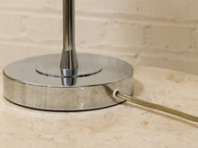 Load image into Gallery viewer, Close-up of a polished silver metal lamp base on a light beige stone surface with a white brick wall background.

