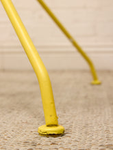 Load image into Gallery viewer, Close-up of a bright yellow metal ladder step or support frame resting on a textured beige carpet against a light wall.
