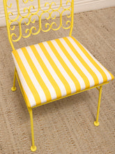 Load image into Gallery viewer, A yellow metal chair with a yellow and white striped cushioned seat, shown on a woven jute rug.
