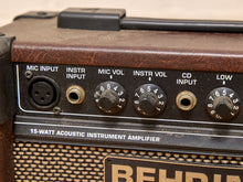 Load image into Gallery viewer, Close-up of a vintage-style acoustic instrument amplifier control panel with knobs, jacks, and a brown textured body.
