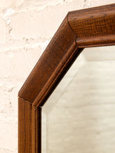 Load image into Gallery viewer, Close-up of a dark brown wooden mirror frame corner against a white brick wall background.
