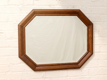 Load image into Gallery viewer, An octagonal wooden wall mirror with a medium brown frame, mounted on a white painted brick wall.
