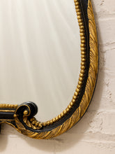 Load image into Gallery viewer, Close-up of an ornate gold and black decorative mirror frame mounted against a white brick wall.
