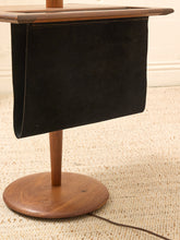 Load image into Gallery viewer, A mid-century modern wooden and leather magazine rack or side table on a textured beige carpet.
