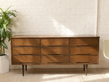 Load image into Gallery viewer, Vintage mid-century modern walnut nine-drawer dresser with recessed wood pulls, long low profile, and tapered legs.
