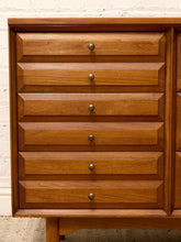 Load image into Gallery viewer, Mid-century modern wooden chest of drawers with six drawers, featuring a warm medium-brown wood finish and small round brass pulls, set against a white brick wall.
